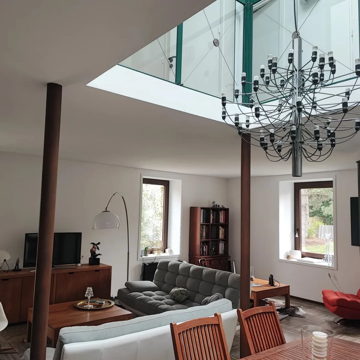 Salon rénové, canapé gris et mobilier en bois
